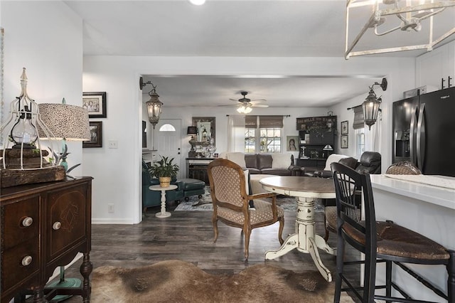 dining space featuring dark wood finished floors, a ceiling fan, and baseboards