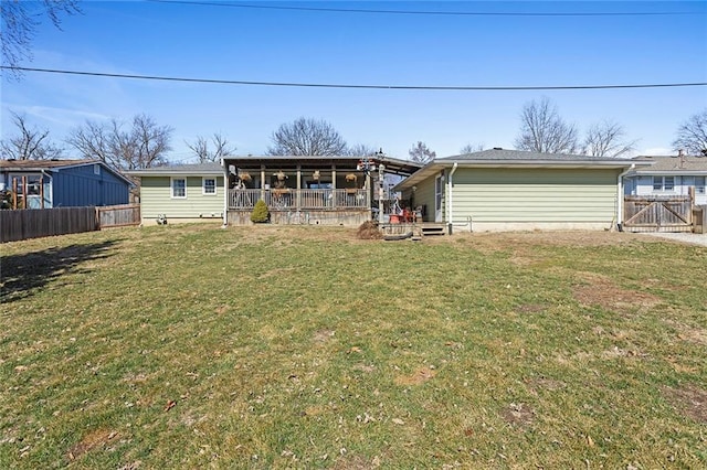 rear view of house featuring a yard and fence