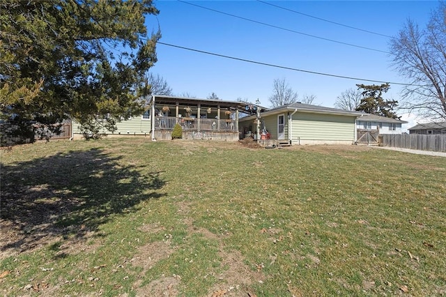 back of house featuring fence and a lawn