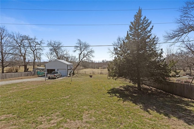 view of yard with a garage, an outdoor structure, and fence