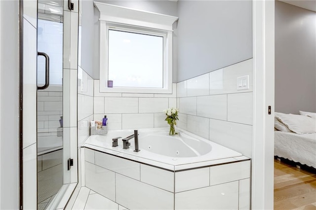 full bath featuring a whirlpool tub, connected bathroom, a stall shower, and wood finished floors