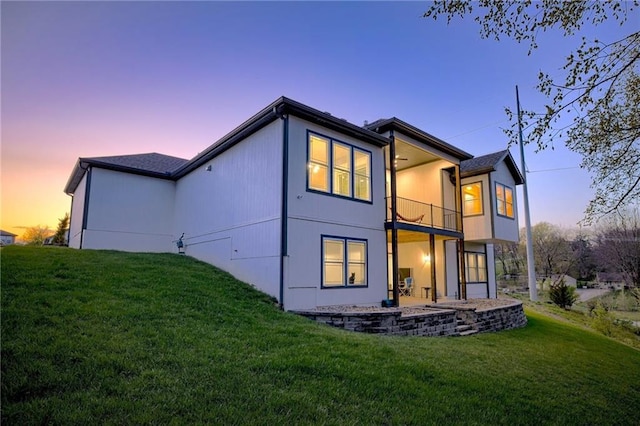rear view of property with a yard, a patio area, and a balcony