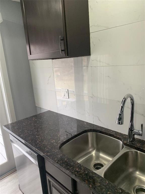 kitchen with a sink, decorative backsplash, dishwasher, and dark stone countertops