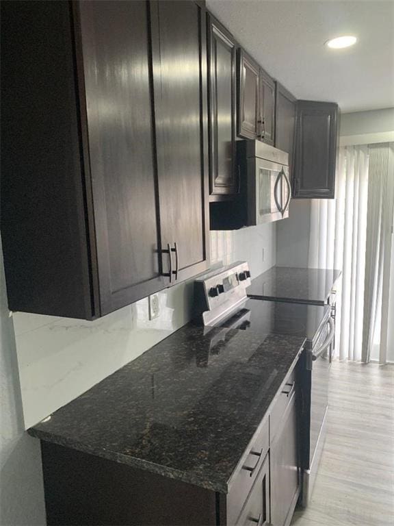 kitchen with dark stone countertops, appliances with stainless steel finishes, and recessed lighting