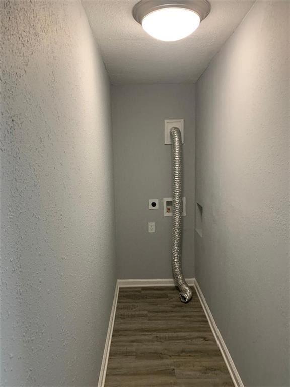 clothes washing area featuring a textured ceiling, wood finished floors, baseboards, hookup for an electric dryer, and laundry area