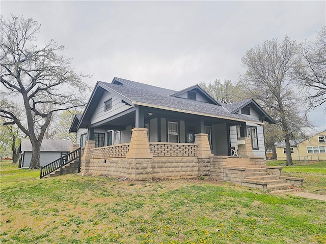 view of front of house featuring roof with shingles, a porch, and a front yard