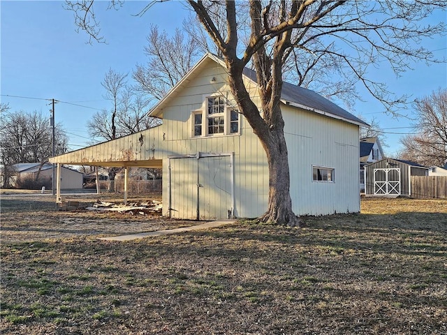 view of side of home featuring a storage shed and an outbuilding