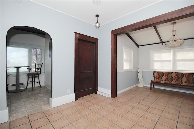 empty room with arched walkways, plenty of natural light, light tile patterned flooring, and a chandelier