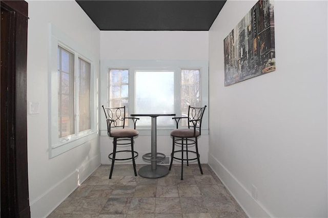dining space featuring baseboards and stone finish floor