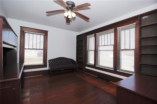 unfurnished room with baseboards, a ceiling fan, and dark wood-style flooring