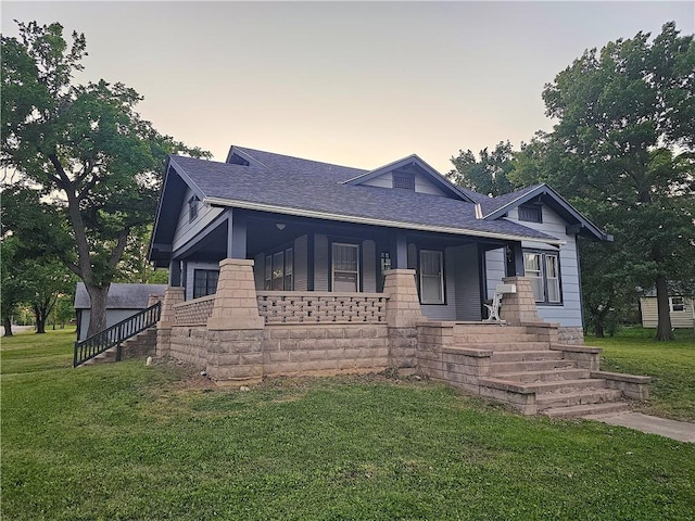 511 S State St, Yates Center, KS 66783 - view of front facade featuring a front lawn, a shingled roof, and a porch