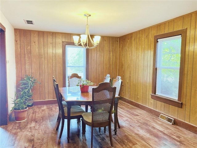 4900 E 219th St, Peculiar, MO 64078 - dining space featuring a chandelier, wood finished floors, and wooden walls