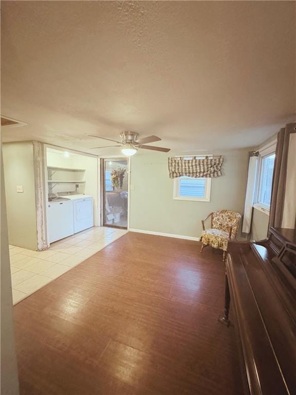 4900 E 219th St, Peculiar, MO 64078 - living room featuring washer and clothes dryer, a ceiling fan, wood finished floors, and healthy amount of natural light