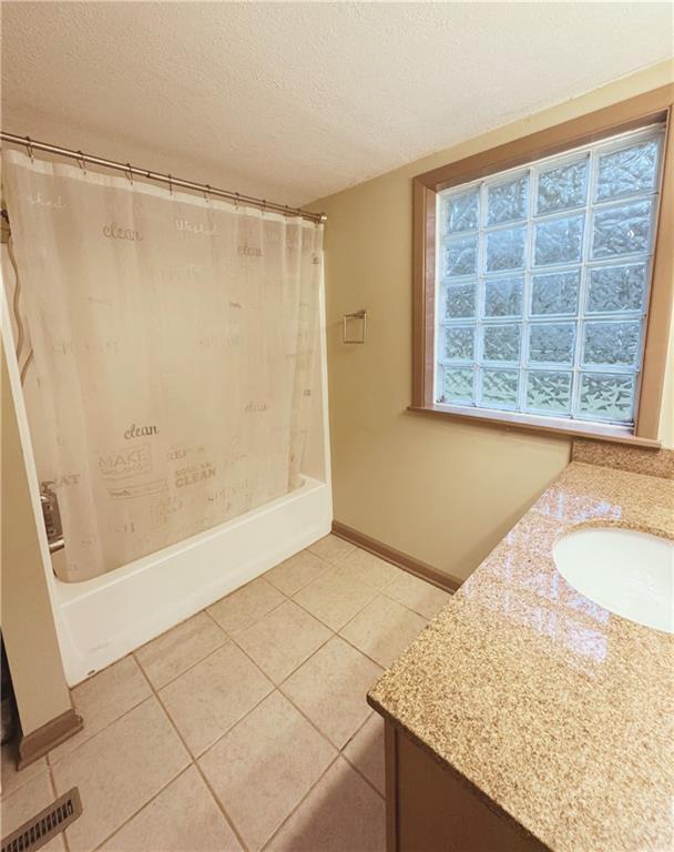 4900 E 219th St, Peculiar, MO 64078 - full bath with vanity, a textured ceiling, shower / bath combination with curtain, and tile patterned floors