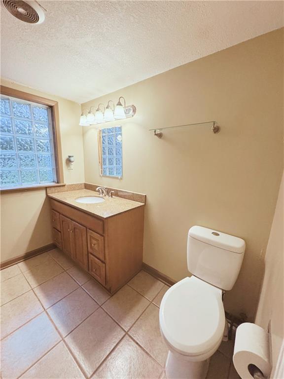 4900 E 219th St, Peculiar, MO 64078 - half bathroom featuring vanity, a textured ceiling, and tile patterned floors