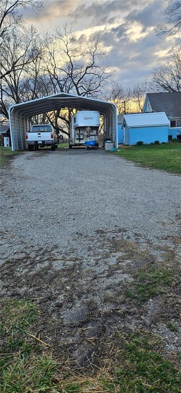 4900 E 219th St, Peculiar, MO 64078 - view of parking / parking lot featuring gravel driveway and a carport