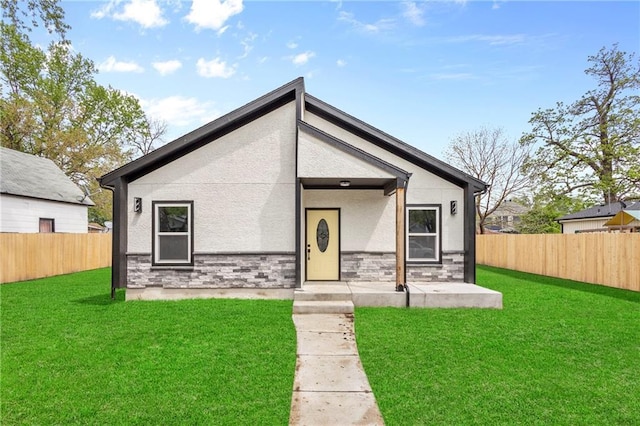 1219 S 36th St, Kansas City, KS 66106 - mid-century inspired home featuring a front yard, stucco siding, stone siding, and a fenced backyard