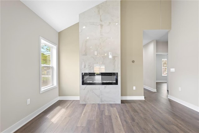1219 S 36th St, Kansas City, KS 66106 - unfurnished living room with baseboards, vaulted ceiling, and wood finished floors
