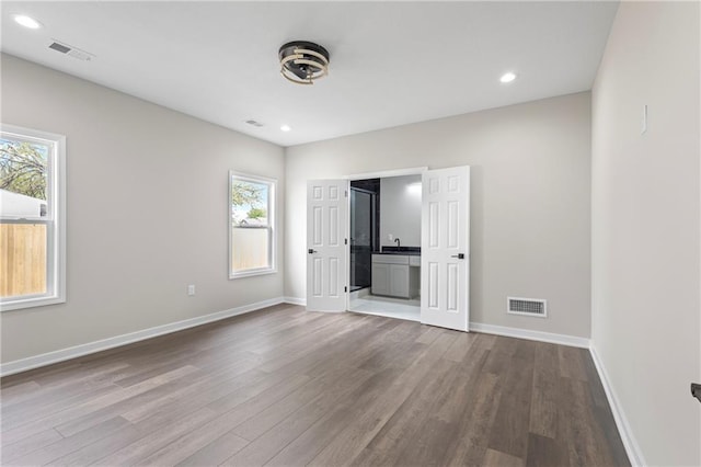 1219 S 36th St, Kansas City, KS 66106 - interior space featuring multiple windows, visible vents, and dark wood-type flooring