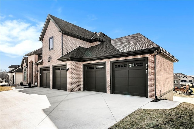 2171 NW Palisades Dr, Riverside, MO 64150 - view of home's exterior with brick siding, concrete driveway, and a garage