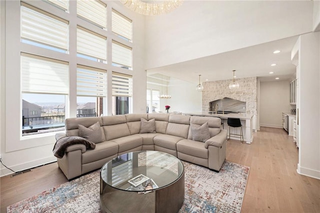 2171 NW Palisades Dr, Riverside, MO 64150 - living room with plenty of natural light, light wood-style flooring, a chandelier, and a high ceiling