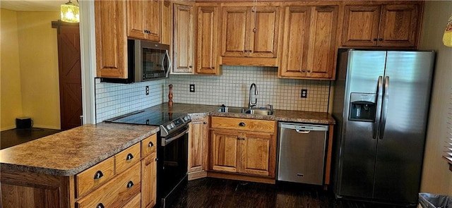 kitchen with appliances with stainless steel finishes, a sink, brown cabinetry, and decorative backsplash