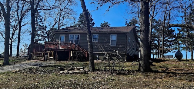view of front of property featuring a wooden deck, an outbuilding, a storage unit, and stairs
