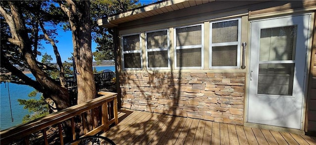 view of home's exterior with stone siding and a wooden deck