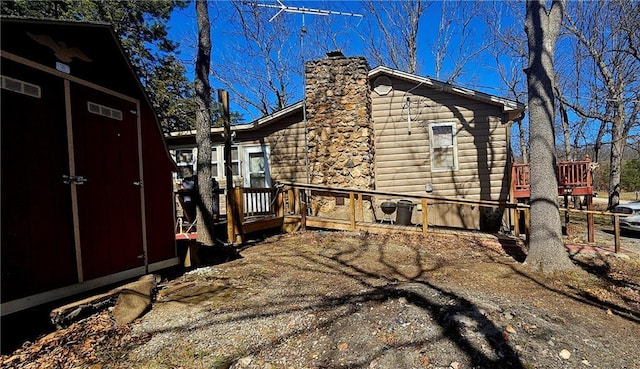 view of side of home with a wooden deck and a chimney