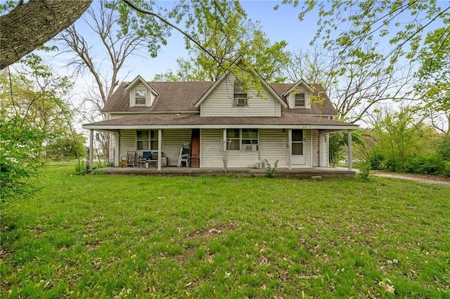 farmhouse-style home with covered porch, a shingled roof, and a front lawn