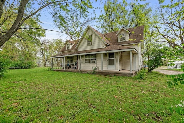 rear view of house with a porch and a yard