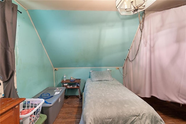 bedroom with an inviting chandelier and wood finished floors