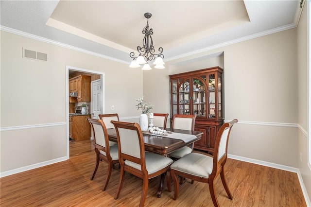 5405 Lakecrest Dr, Shawnee, KS 66218 - dining area with a tray ceiling, light wood-style floors, a chandelier, and crown molding