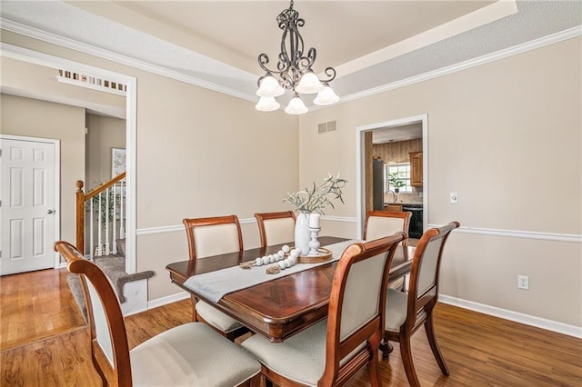 5405 Lakecrest Dr, Shawnee, KS 66218 - dining room with a chandelier, light wood-style flooring, a raised ceiling, ornamental molding, and stairway