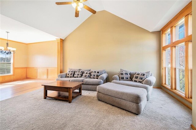18125 Cypress Bnd, Basehor, KS 66007 - carpeted living area with a chandelier, plenty of natural light, a wainscoted wall, ceiling fan, and high vaulted ceiling