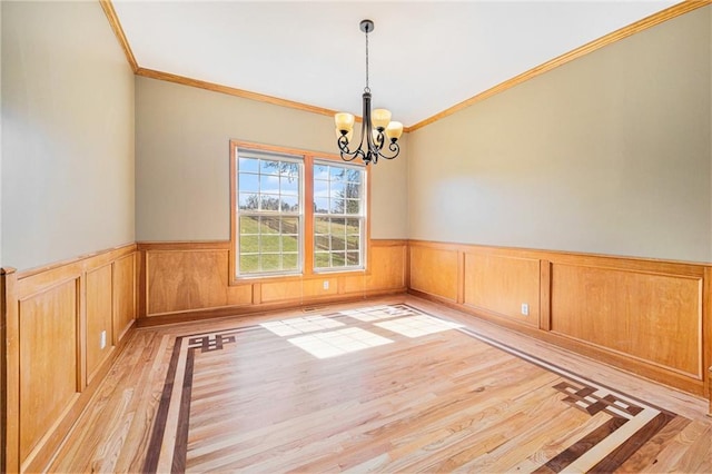 18125 Cypress Bnd, Basehor, KS 66007 - empty room with a chandelier, light wood-type flooring, crown molding, and wainscoting