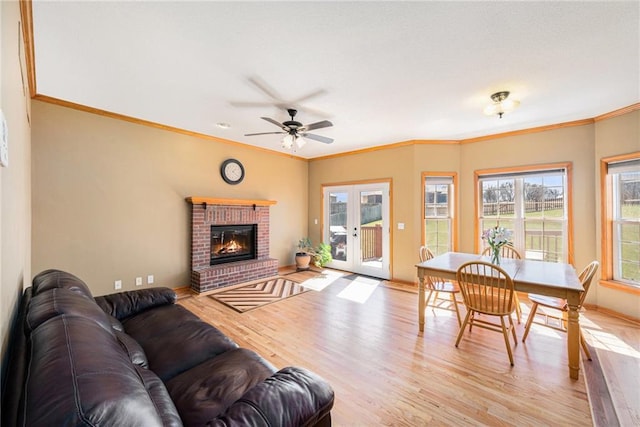 18125 Cypress Bnd, Basehor, KS 66007 - living room with light wood-style floors, a ceiling fan, baseboards, a brick fireplace, and ornamental molding