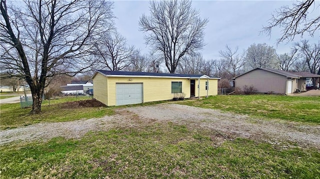 705 Heylman St, Fort Scott, KS 66701 - exterior space featuring a lawn, a garage, and dirt driveway
