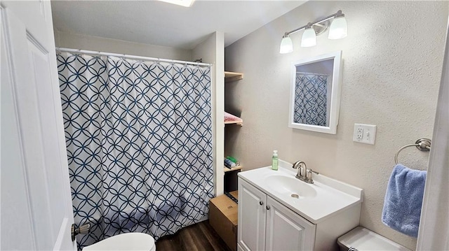 705 Heylman St, Fort Scott, KS 66701 - bathroom featuring vanity, toilet, a textured wall, a shower with shower curtain, and wood finished floors