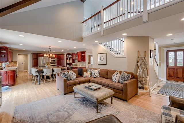 10318 Sagamore Rd, Leawood, KS 66206 - living room featuring light wood-type flooring, stairs, a high ceiling, and recessed lighting