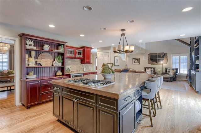 10318 Sagamore Rd, Leawood, KS 66206 - kitchen featuring stainless steel gas stovetop, a chandelier, open floor plan, dark brown cabinets, and recessed lighting