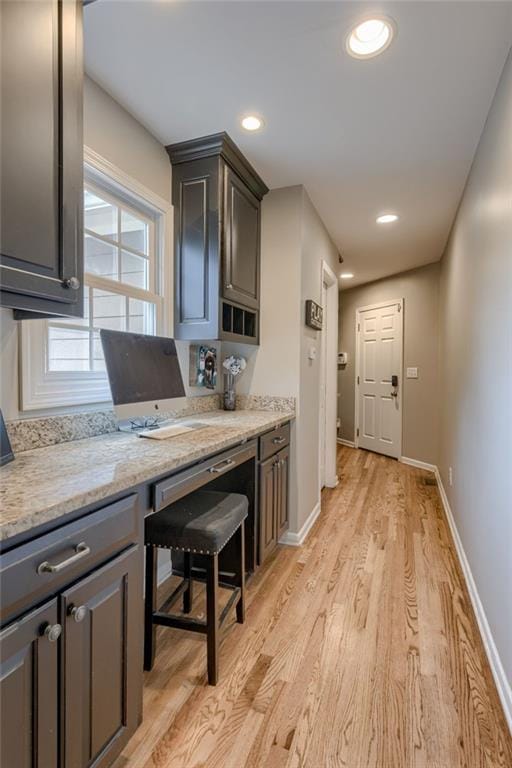 10318 Sagamore Rd, Leawood, KS 66206 - kitchen featuring light wood finished floors, built in study area, recessed lighting, and light stone countertops