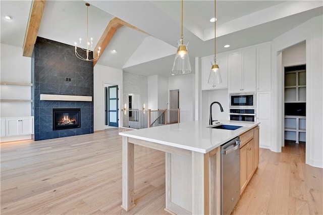 24936 W 98th Pl, Lenexa, KS 66227 - kitchen featuring stainless steel appliances, open floor plan, light wood-style floors, light countertops, and decorative light fixtures