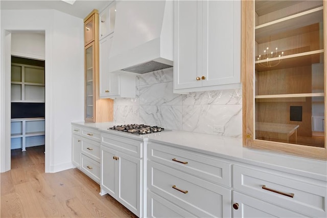 24936 W 98th Pl, Lenexa, KS 66227 - kitchen featuring custom range hood, stainless steel gas stovetop, light wood-type flooring, backsplash, and light countertops