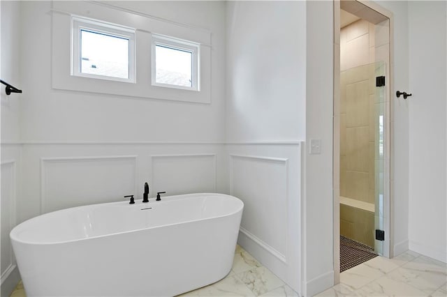 24936 W 98th Pl, Lenexa, KS 66227 - bathroom with marble look tile flooring, a decorative wall, a freestanding tub, a stall shower, and a wainscoted wall