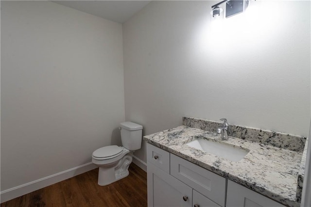 1702 N 2nd St, Neodesha, KS 66757 - half bath with toilet, vanity, baseboards, and wood finished floors