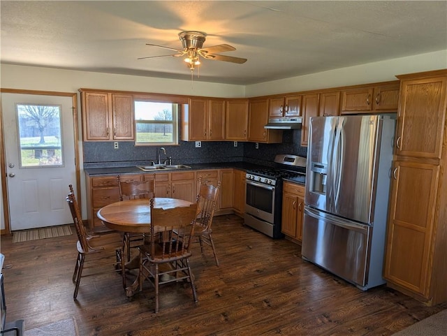 kitchen featuring dark countertops, backsplash, ceiling fan, dark wood finished floors, and stainless steel appliances