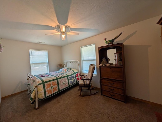 carpeted bedroom featuring baseboards, visible vents, a textured ceiling, and ceiling fan