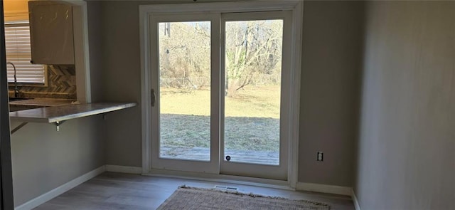 entryway with light wood-style flooring and baseboards