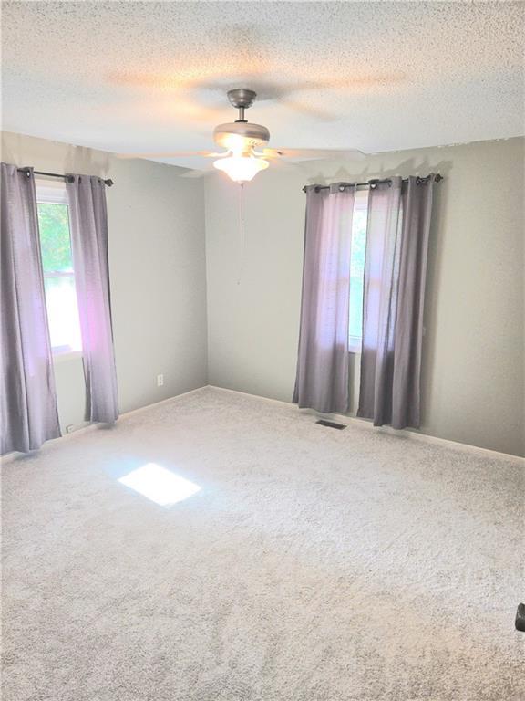 3402 Messanie St, Saint Joseph, MO 64501 - spare room featuring a textured ceiling, carpet flooring, and ceiling fan